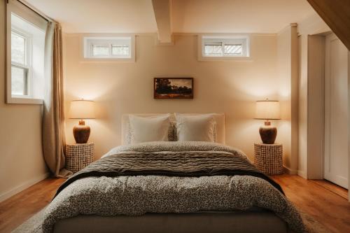 a bedroom with a large bed with two lamps at Wren Cottage - Design Cabin with Secret Brook in Cochecton