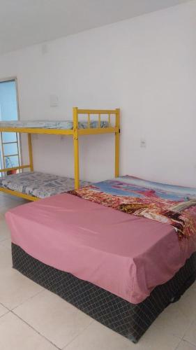 a bunk bed with a pink blanket on top of it at Hostel OS ETERNOS MONIS in Rio de Janeiro