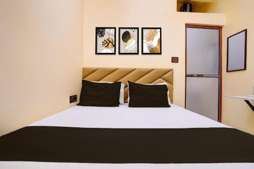 a bedroom with a large bed with four pictures on the wall at Hotel O Utsav In in Jabalpur