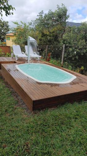 a swimming pool with a fountain and a deck at Chalé Aconchego da Lapinha Vista para Montanhas Piscina e Natureza in Santana do Riacho