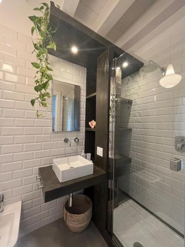 a bathroom with a sink and a glass shower at La Casa di Mariano in Terrasini