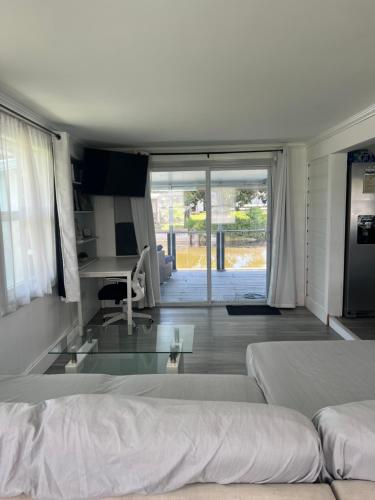 a living room with two beds and a glass table at Water front Lake House in Okeechobee