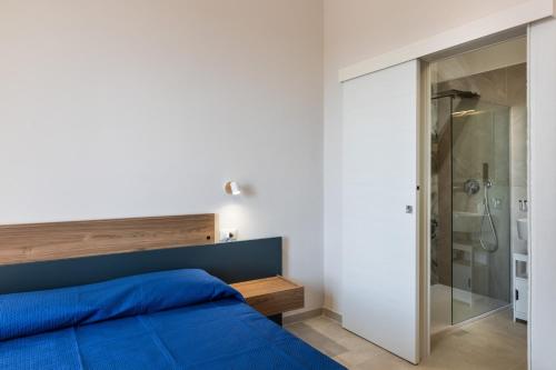 a bedroom with a blue bed and a shower at Casa Amarantia-Appartamento 2 in Noto