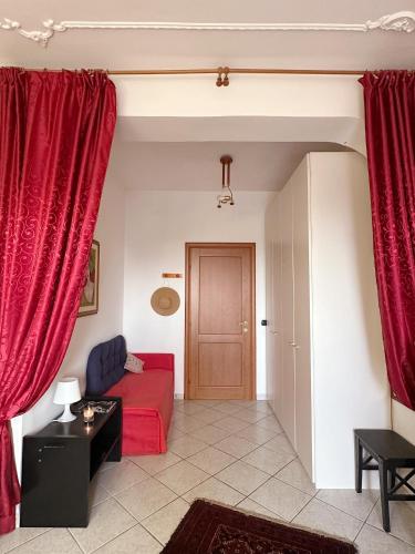 a living room with red curtains and a red couch at Stars Home in Tropea