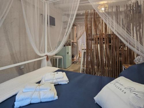 a bedroom with two towels sitting on a bed at LA PIGNA BLU CasaVacanza con Piscina in Botrugno