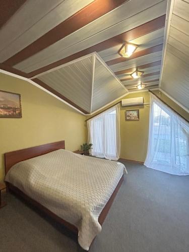 a bedroom with a bed and two windows at Гостьовий Дім Guest House in Kotowsk