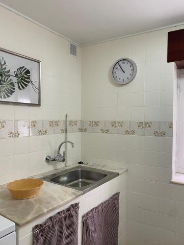 a kitchen with a sink and a clock on the wall at Las Tres Luces Casa 1 in Llanes