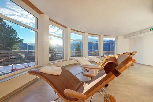 a room with a bunch of chairs and windows at Wellness Aparthotel Panorama Alpin - Ferienwohnungen Jerzens im Pitztal in Jerzens