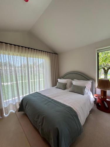 a bedroom with a large bed with a large window at Dovecote Houses in Viana do Castelo