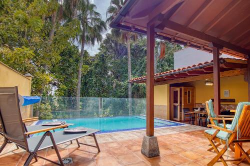 an outdoor patio with a swimming pool and chairs at 4BR Wellness Villa- Pool, Sauna, Gym in Puerto de la Cruz