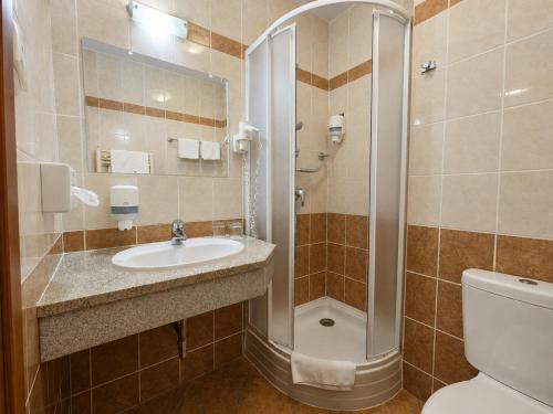 a bathroom with a shower and a sink and a toilet at Hungarospa Thermal Hotel in Hajdúszoboszló