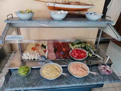 a buffet with different types of food in bowls at Nautica Stúdió by HelloBalatonlelle in Balatonlelle