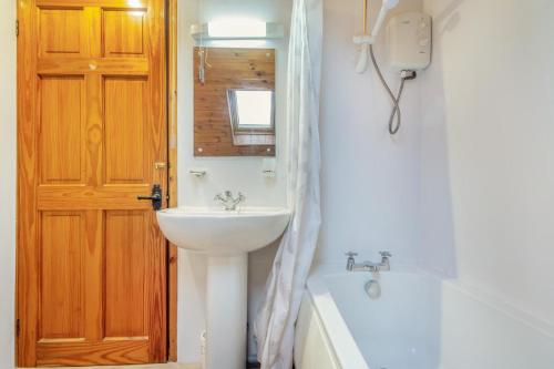 a bathroom with a sink and a toilet and a mirror at 2 Bed in Betws-y-Coed oc-84026 in Penmachno