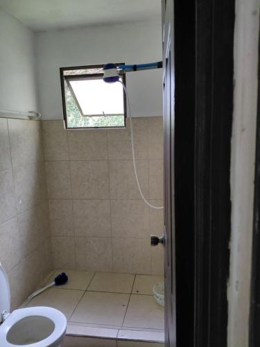 a bathroom with a shower with a toilet and a window at San Remo 1 in San Pedro