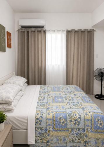 a bedroom with a bed with a quilt on it at LJ CCC CozyNest at 32 Cebu Fast Wifi Netflix You tube in Cebu City