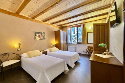 a hotel room with two beds and a television at Antico Borgo Petralia in Zafferana Etnea