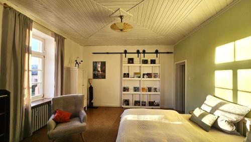 a bedroom with a bed and a chair and a ceiling at Helle Ferienwohnung - Südeifel bei Neuerburg in Ammeldingen
