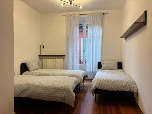 a room with three beds and a window at Casa Limmy in Intra