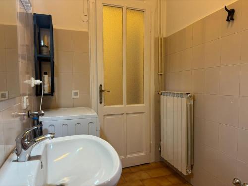 a bathroom with a white sink and a door at Casa Limmy in Intra