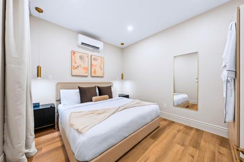 a bedroom with a large bed and a mirror at Casa Hotels Gerrard Newly Built Suite Steps to Transit in Toronto