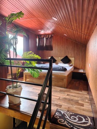 a bedroom with a bed and a table with a plant at Nizel Inn in Darjeeling