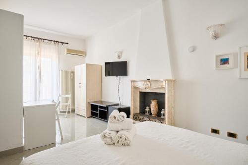 a white bedroom with towels on a bed at B&B Soldano in Peschici