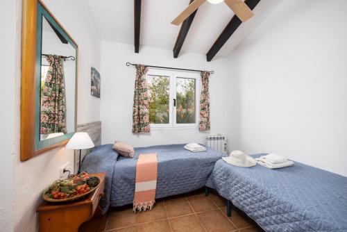 two twin beds in a room with two windows at Villa Ca Nostra in Cala en Porter