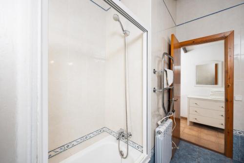 a bathroom with a shower and a tub at Villa Ca Nostra in Cala en Porter