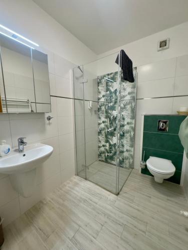 a bathroom with a shower and a sink and a toilet at Pension Kiwi in Mikulov