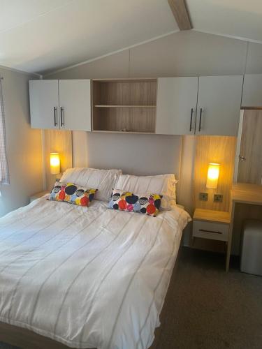 a bedroom with a large white bed with two pillows at Aqua bay whistable in Swalecliffe