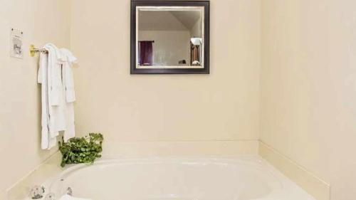 a white bathroom with a tub and a mirror at WP651 Smokin' Views Penthouse in Pigeon Forge