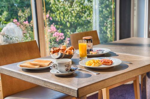 a breakfast table with breakfast foods and coffee and toast at Logis Le Relais de Sassenage in Sassenage
