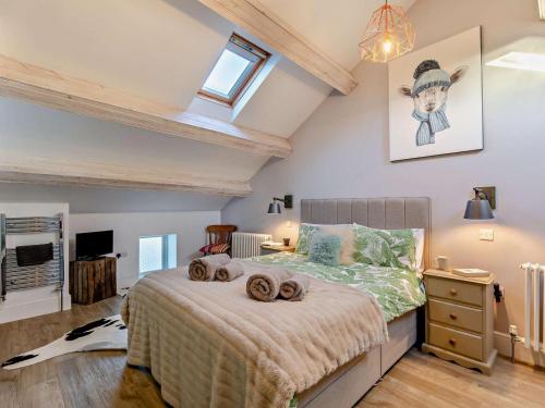 a bedroom with a bed with blankets and a television at 2 Bed in Settle oc-g0051 in Settle