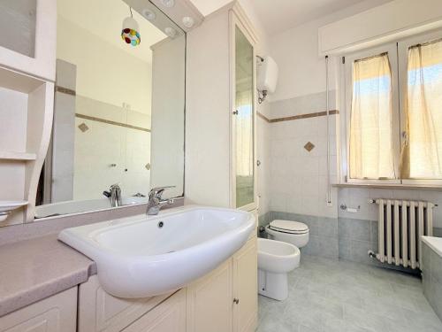 a white bathroom with a sink and a toilet at SE238 - Marotta, quadrilocale con corte privata in Marotta