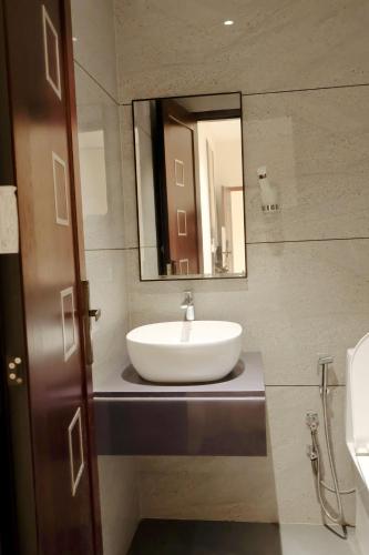 a bathroom with a white sink and a mirror at Shree Priyam Residency in Rāmanāthapuram