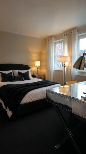 a bedroom with a large bed and a glass table at Hotel am Doktorplatz in Rheda-Wiedenbrück