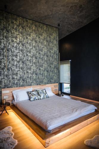 a bedroom with a large bed with a black wall at Ascent Lodge -Jacuzzi si Panoramic View in Petreasa