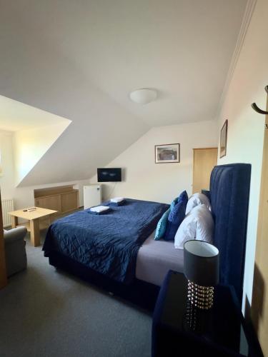 a bedroom with a bed with a blue comforter at Pension Kiwi in Mikulov
