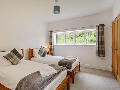 a bedroom with two beds and a window at 4 Bed in Chard oc-83501 in Combe Saint Nicholas