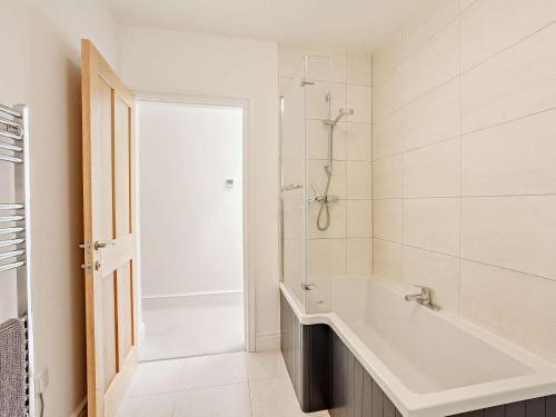 a white bathroom with a tub and a shower at 4 Bed in Chard oc-83501 in Combe Saint Nicholas
