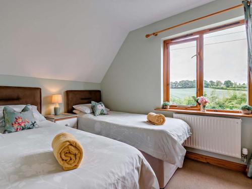 two beds in a room with a window at 3 Bed in Ledbury oc-77378 in Wilton
