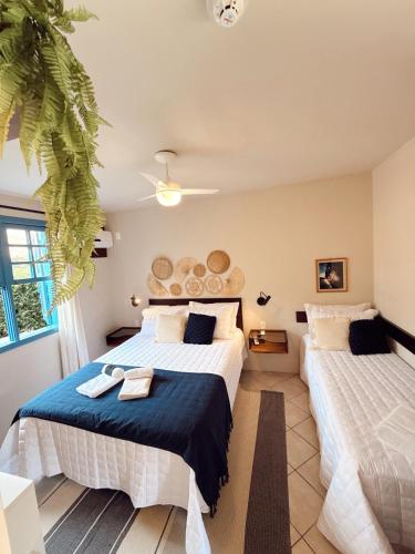 a bedroom with two beds and a large window at Hotel Pousada da Lagoa - Casa Californiana in Garopaba
