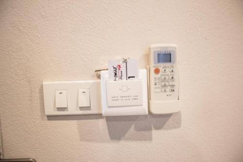 a wall with a remote control holder on a wall at Naiya Place in Kanchanaburi