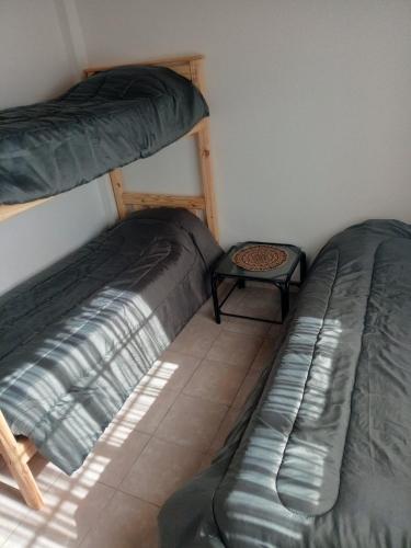 two bunk beds in a room with a table at El Galpon Aparts in General Pacheco