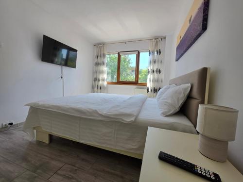 a bedroom with a bed with a television and a desk at Konstanzer Podu Ros 11 - Spacious Apt - Palas Mall - AC in Iaşi