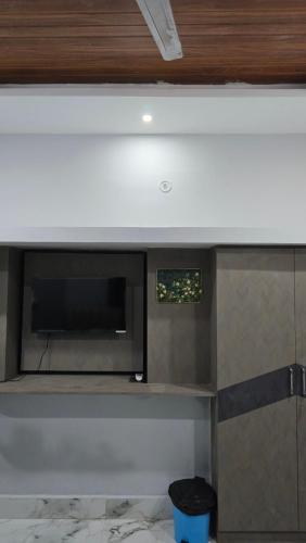 a kitchen with a microwave and a tv on a wall at Deoghar BnB in Deoghar