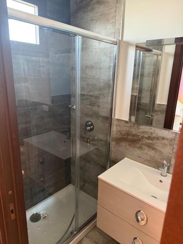 a bathroom with a shower and a sink at Illumina House 3 in Giurdignano