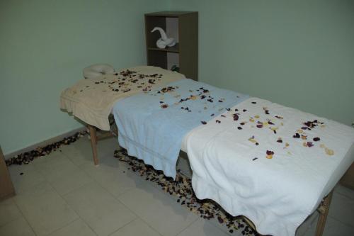 a bed with brown petals on a white blanket at Momona Hotel in Addis Ababa