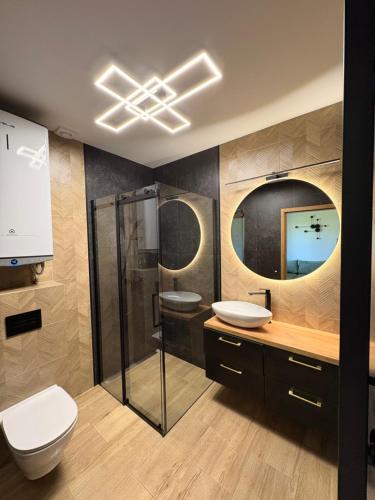 a bathroom with two sinks and a shower and a toilet at Domki Kamila in Grzybowo
