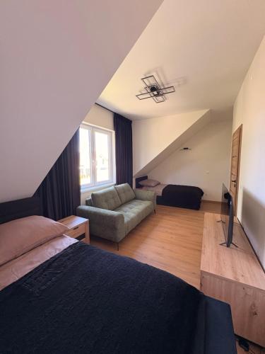 a bedroom with a bed and a couch at Domki Kamila in Grzybowo